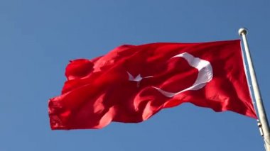 Türk Bayrağı. Mavi arka planda Türk Bayrağı sallıyor. 4K video. 23 Nisan veya 19 Mayıs veya 30 Ağustos veya 29 Ekim görüntüleri. Gürültü dahil.