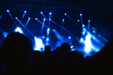 Konser. Sahnedeki spot ışıkları sis etkisindeydi. Gürültü dahil. Arkaplana seçici odak.