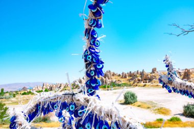 Goreme Kapadokya 'daki ağaç dalında nazar boncuğu ya da nazar boncugu. Türkiye 'deki arka plan fotoğrafına git. Türk kültürü.