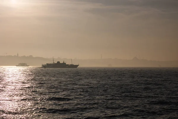 İstanbul arka planı. İstanbul silueti ve Uskudar ilçesinden sisli havada feribot.