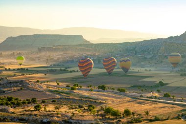 Güneş doğarken Goreme Kapadokya 'ya sıcak hava balonları indi. Türkiye 'deki arka plan fotoğrafına git. Gürültü dahil.