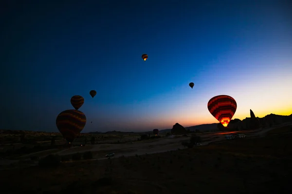 カッパドキアの日の出に熱気球のシルエット トルコへの旅行の背景写真 含まれるノイズ — ストック写真