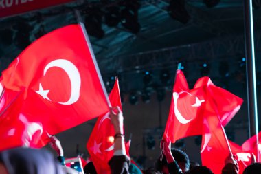Turkis bayrakları. Ulusal bayram kutlamalarında Türk bayrakları sallıyor. 19 Mayıs veya 23 Nisan veya 30 Ağustos veya 29 Ekim. Hareket bulanıklığı ve gürültü dahil.