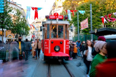 Istiklal Caddesi 'nde nostaljik tramvay. Tramvayda hareket bulanıklığı ve insanlar. İstanbul Türkiye - 11.13.2021