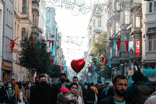 Istiklal Caddesi 'ndeki insanlar ya da kalp şeklinde bir balonla İstiklal Caddesi. İstanbul Türkiye - 11.13.2021