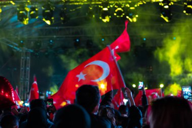 Gece bir kutlamada Türk Bayrakları sallamak. Türkiye 'nin ulusal günleri. Bayraklarda hareket bulanıklığı ve odaklanmış efekt.