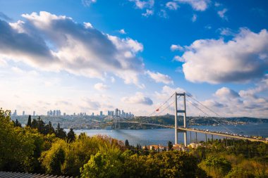 İstanbul manzaralı. Günbatımında bulutlu gökyüzü ile İstanbul ve Boğaz Köprüsü 'nün geniş açılı görüntüsü. Seçici odak.