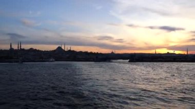 Günbatımında İstanbul 'un silueti. İstanbul arka plan 4k video seyahat. Eminonu bölgesi ve Galata köprüsü..