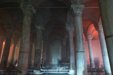 The Basilica Cistern or Yerebatan Sarnici with tourists. Travel to Istanbul concept photo. Noise and grain included. Selective focus. Motion blur on people. Istanbul Turkey - 8.3.2022