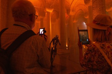 Tourists taking a picture of Basilica Cistern or Yerebatan Sarnici. Travel to Istanbul background photo. Noise or grain included. Selective focus. Istanbul Turkey - 8.3.2022