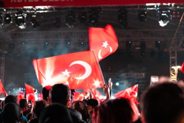 Turkish people waving Turkish Flag in night event. 29th october republic day or literally in Turkish 29 ekim cumhuriyet bayrami background photo. Noise and motion blur included.