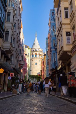 Turistler ve Galata Kulesi dikey fotoğraf. İstanbul 'a git. İstanbul Türkiye - 8.20.2022
