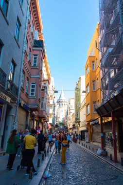 Galata Kulesi ve turistler. İstanbul 'daki dikey arka plan fotoğrafına git. Beyoğlu bölgesinde turistler. İstanbul Türkiye - 8.20.2022
