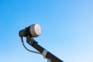 Besleme borusundaki LNB, mavi gökyüzü arka planında izole edilmiş. Uydu iletişimi arkaplan fotoğrafı.