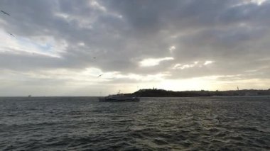İstanbul gün batımında bulutlu bir gökyüzü ve feribottan martılarla manzaralı. Türkiye 'ye git arka plan 4K videosu. İstanbul Türkiye - 3.30.2021
