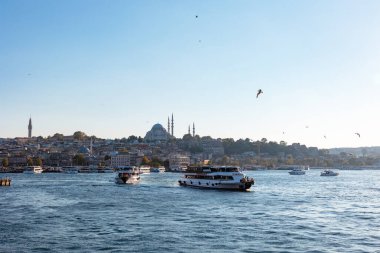 İstanbul manzarası gün batımında. Süleyman Camii ve Galata Köprüsü 'nden feribot. İstanbul Türkiye - 8.20.2022