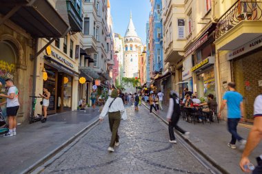 İstanbul 'a git. Galata Kulesi ve sokaktaki turistler. İstanbul Türkiye - 8.20.2022