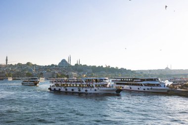 İstanbul manzaralı. Günbatımında feribot ve Süleyman Camii. İstanbul Türkiye - 8.20.2022