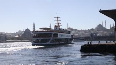 İstanbul 'un ünlü feribotu ve İstanbul silueti. Karaköy İskelesi 'nden kalkan feribot. El kamerasının etkisi. Türkiye 'ye seyahat videosu. İstanbul Türkiye - 9.30.2022 