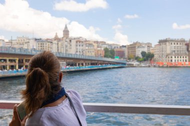 Boğaziçi 'nde bir feribotla Galata Kulesi' ne giden turist kadın. İstanbul 'daki arka plan fotoğrafına git.