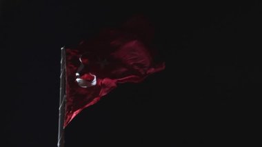 Geceleri Türk Bayrağı sallıyor. Türk Bayrağı arka plan 4K videosu. Türkiye 'nin ulusal günleri. Gürültü ve tahıl dahil.