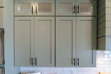 Ahşap mutfak dolapları asılı cam levhalar beyaz kiremit duvarlar