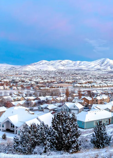 Vertical Une vue sur la vallée et les maisons avec les montagnes et le ciel bleu comme arrière-plan — Photo