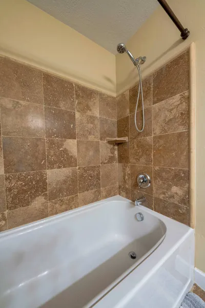 Banheira com chuveiro de mão montado na parede e torneira — Fotografia de Stock