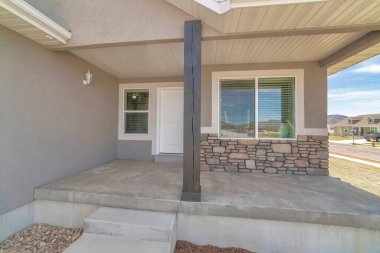 Dış görünüşü taş kaplama ve beyaz kapısı olan küçük bir ev.