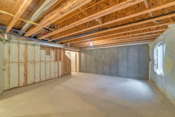 Unfinished basement with a plastic vapor barrier on the wall — Stock Photo, Image