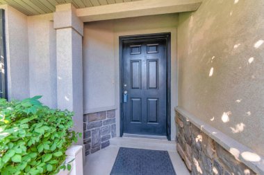 Ahşap kapılı dış kapısı kilitli ve siyah paspası var.