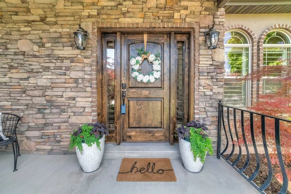 Dark wooden front door with decorative plants and wreath — Stock Photo, Image