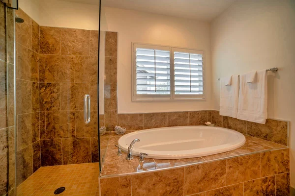 Interior do banheiro com telhas bronzeadas brilhantes e janela — Fotografia de Stock