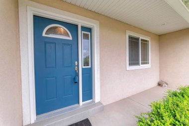 Mavi ön kapı kilitli, kemerli cam camlar ve yan kapılar.