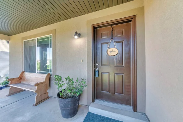 Braune Haustür mit Schließfach und hängendem Willkommensschild — Stockfoto