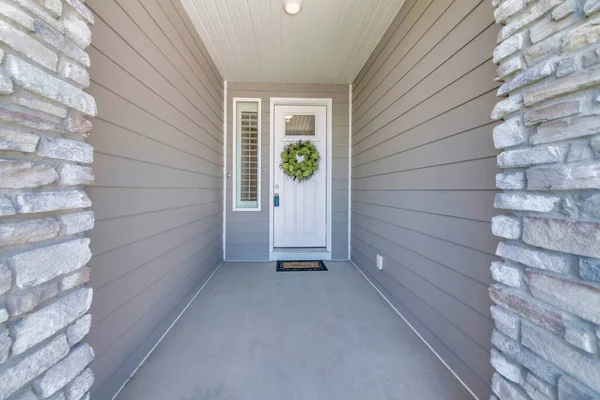 Ingang van een huis in het midden van een grijs houten vinyl gevel en stenen fineer aan de voorzijde — Stockfoto