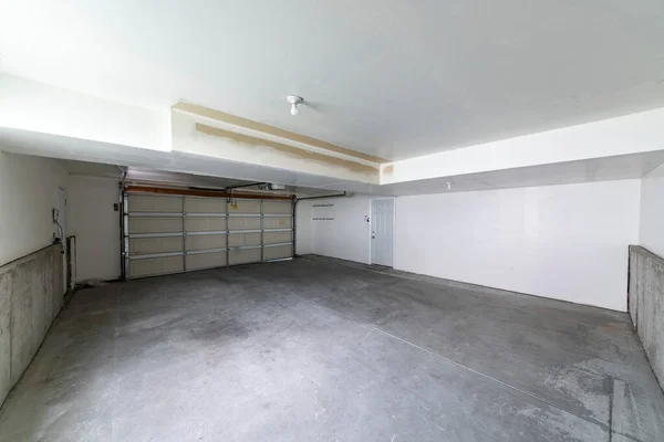 Intérieur de garage avec porte sectionnelle automatique et porte coupe-feu blanche — Photo