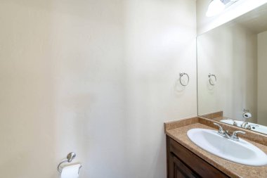 Tuvalet köşesinde lavabo ve duvar kağıdı rulosu var.