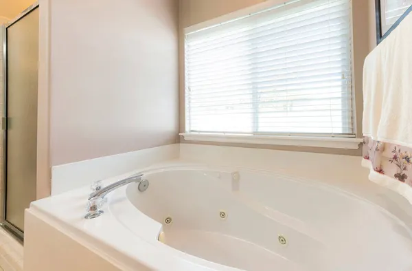 Bañera de hidromasaje en un baño con ventanas y persianas — Foto de Stock