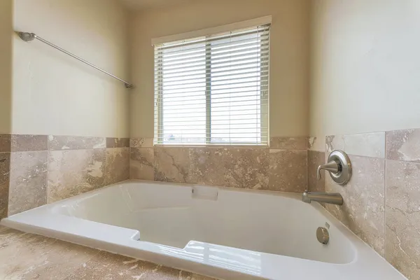 Banyoda, etrafı mermer kiremitlerle çevrili bir küvet. — Stok fotoğraf