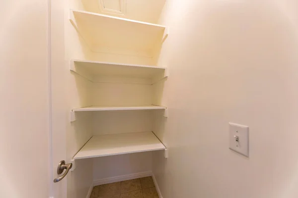 Empty linen closet with white interior and alcove shelves