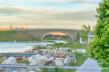 Oquirrh Gölü 'ndeki ahşap rıhtımda Daybreak, Utah' ta tabela direği var.