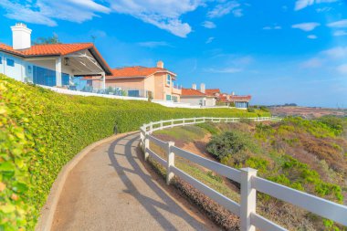 Güney Kaliforniya 'da bir tepenin kenarında beyaz parmaklıklar olan eğri beton bir patika.