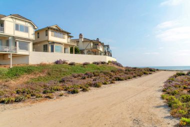 Carlsbad, California 'daki çitli sahil evlerinin dışındaki toprak yol.