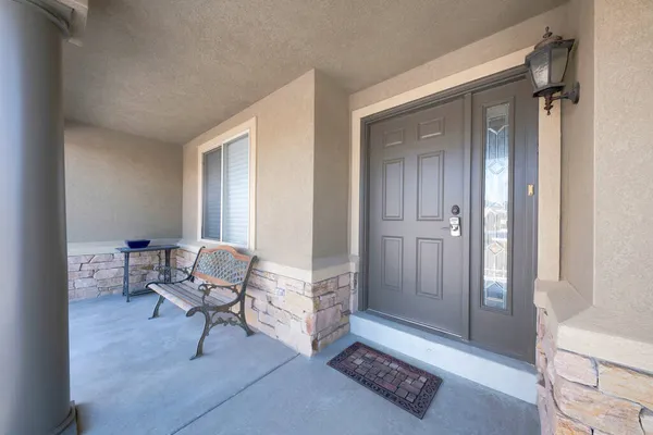 Puerta delantera exterior de una casa con banco y mesa a un lado — Foto de Stock