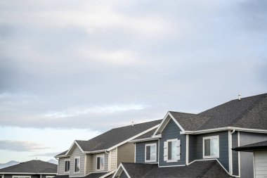 Asfalt kiremitli çatıları ve bacaları olan iki katlı evlerin ikinci katı.