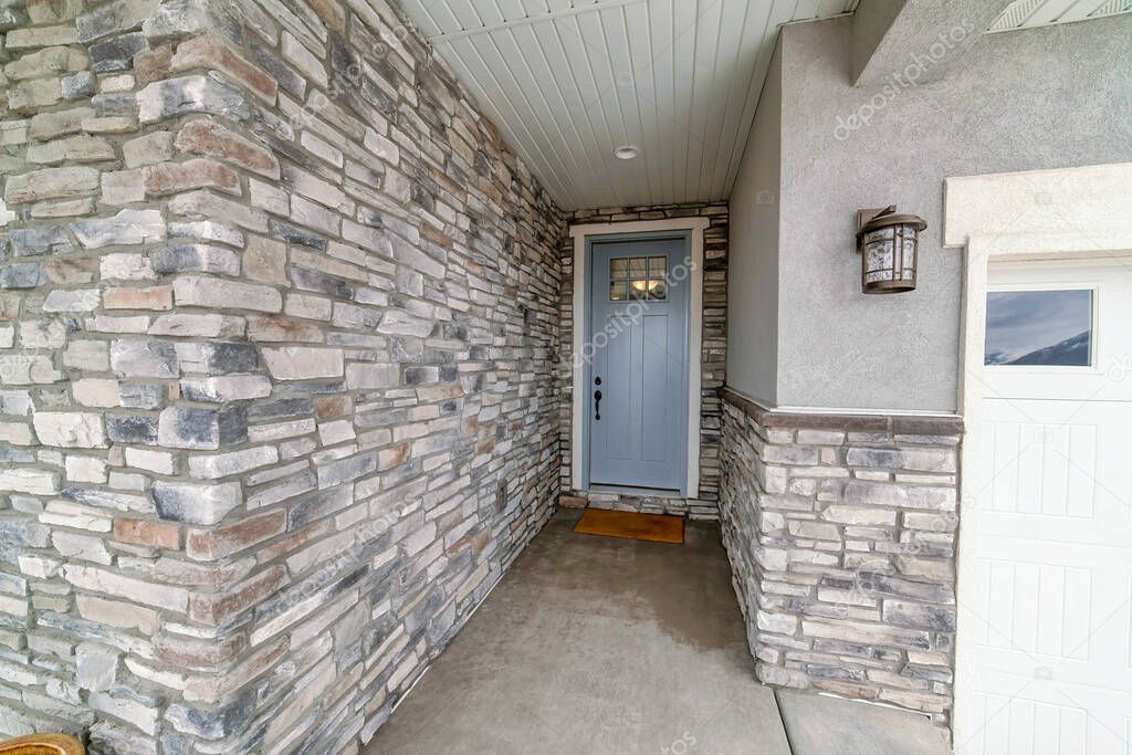 Entrance of a house in the middle of the walls with stone veneer siding