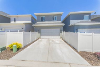 Beyaz vinil çitli bir evin arkasındaki garaja yerleştirilmiş.