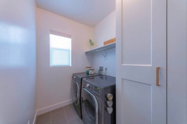 Beyaz iç çamaşırlı çamaşır odası ve keten tonlu pencere.