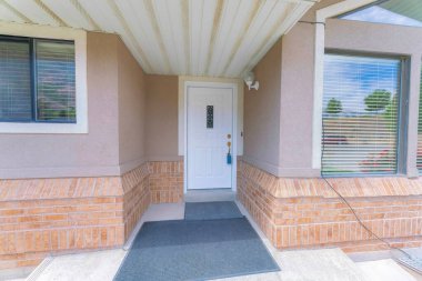 İşlenmiş demir paneli ve kilitli kutusuyla beyaz ön kapı.